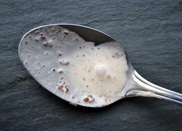 A spoon with melted Mascarpone Ice Cream with Espresso Chocolate Shavings